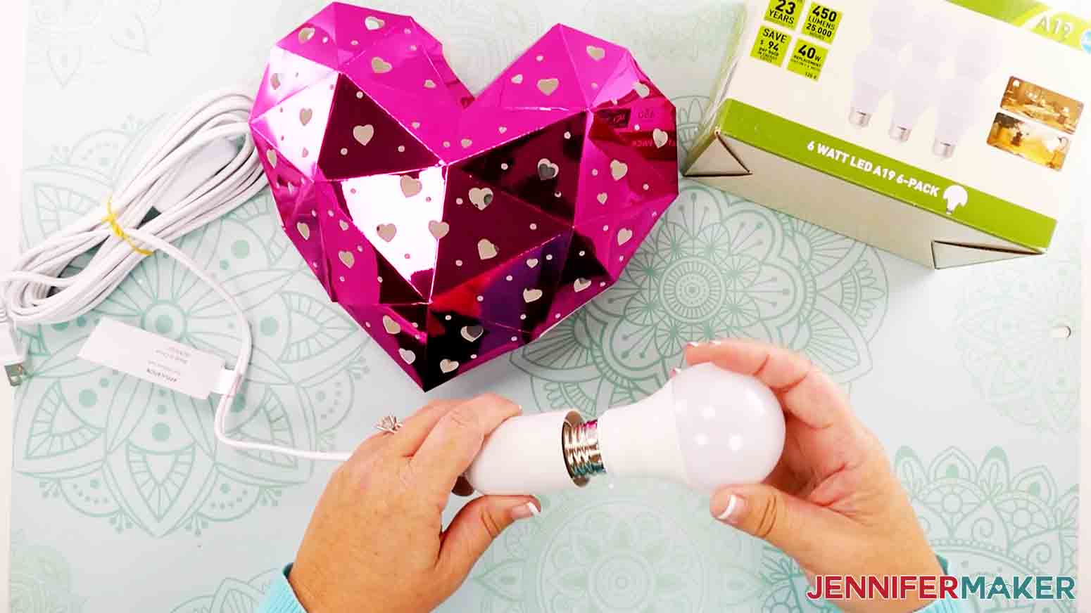 screwing in light bulb to light the heart lantern