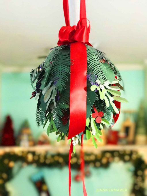 DIY Holiday Kissing Ball made with paper mistletoe, paper holly, and paper pine branches | Made on a Cricut | #cricut #svg | free pattern and cut files #christmasdecor