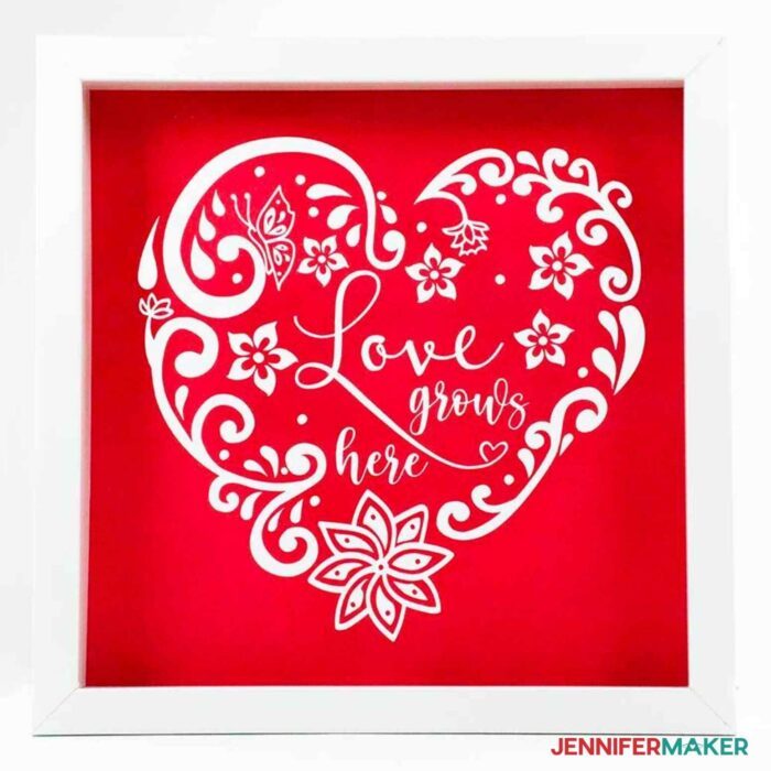 Intricate heart cut from white vinyl shadowbox with a red background made with the wet vinyl transfer method