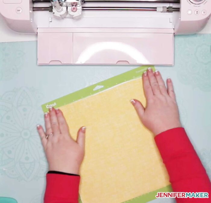 Putting the bonded fabric on the cutting mat to cut with Cricut Explore