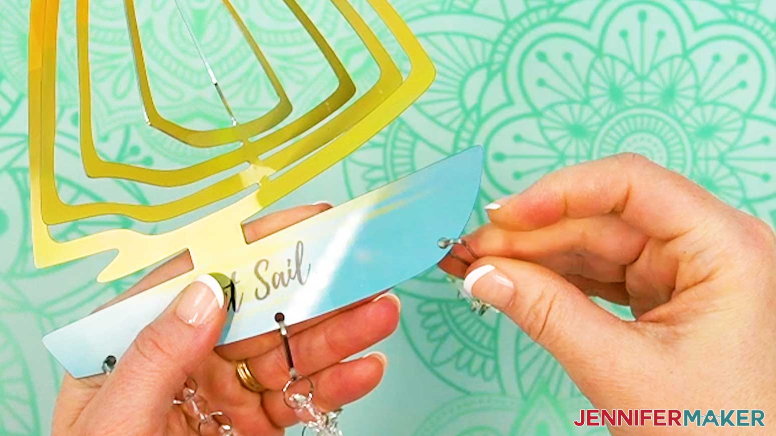 Attach the dangles to the main piece of the wind spinner with the included hangers.