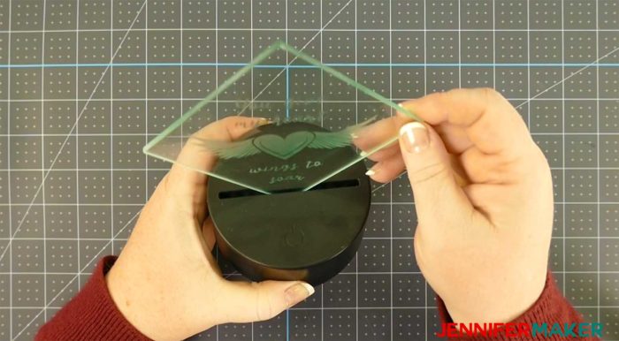 Putting hot glue in an LED light base to light up a glass etching