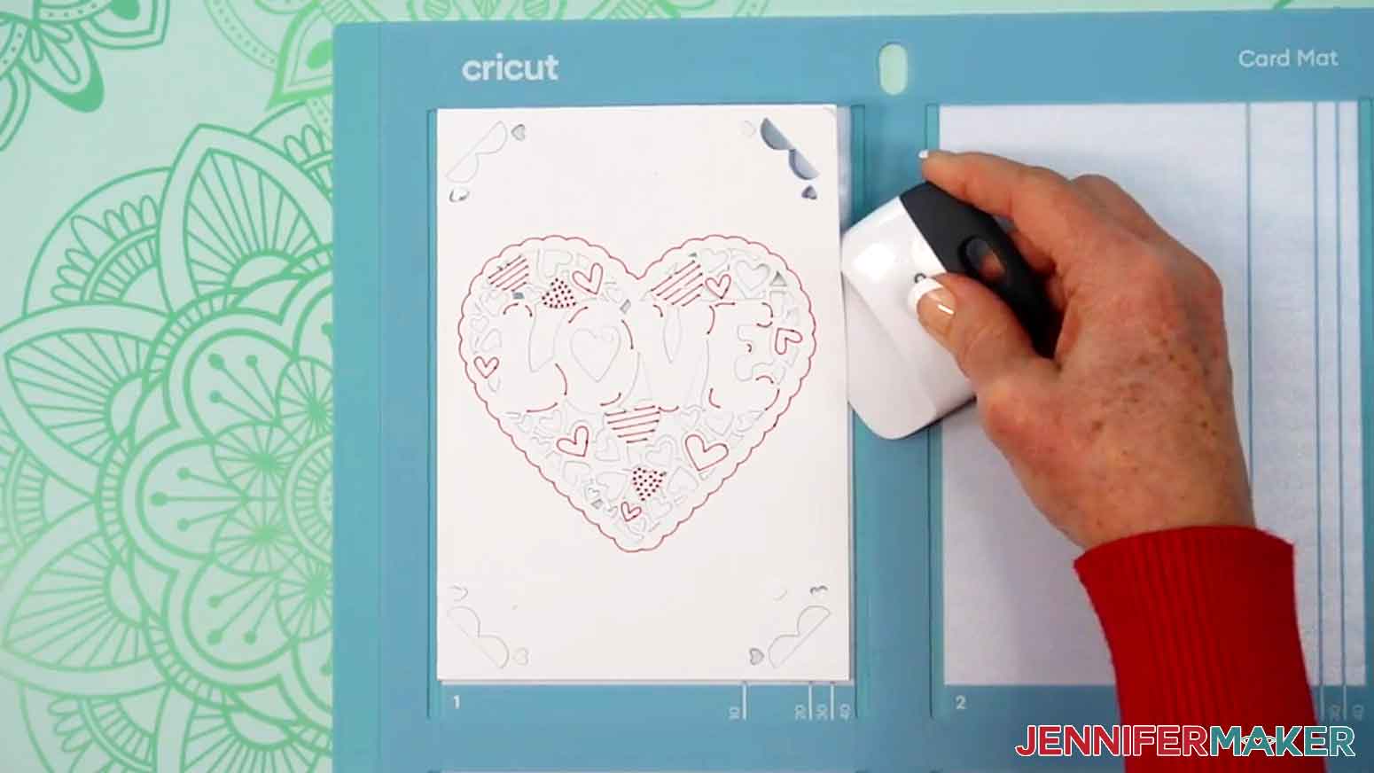 A scraper is being used to gently lift the card off of the card mat.