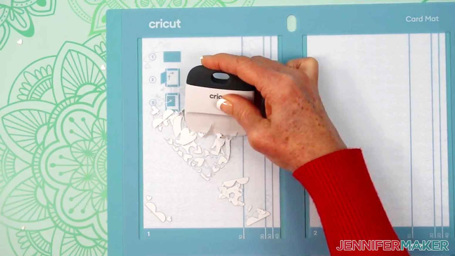 A scraper is being used to scrape all the left over pieces from the card mat.