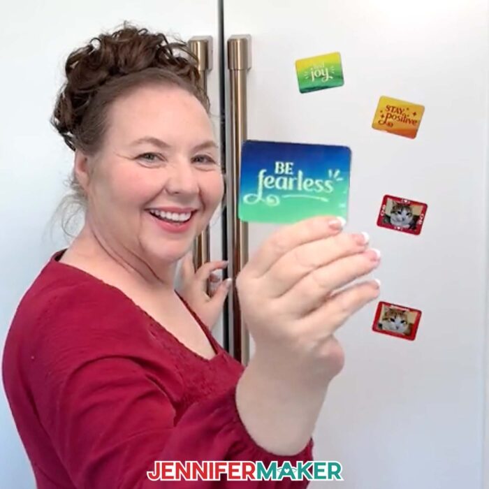 Jennifer stands in front of a fridge holding up a magnet that says "Be fearless."