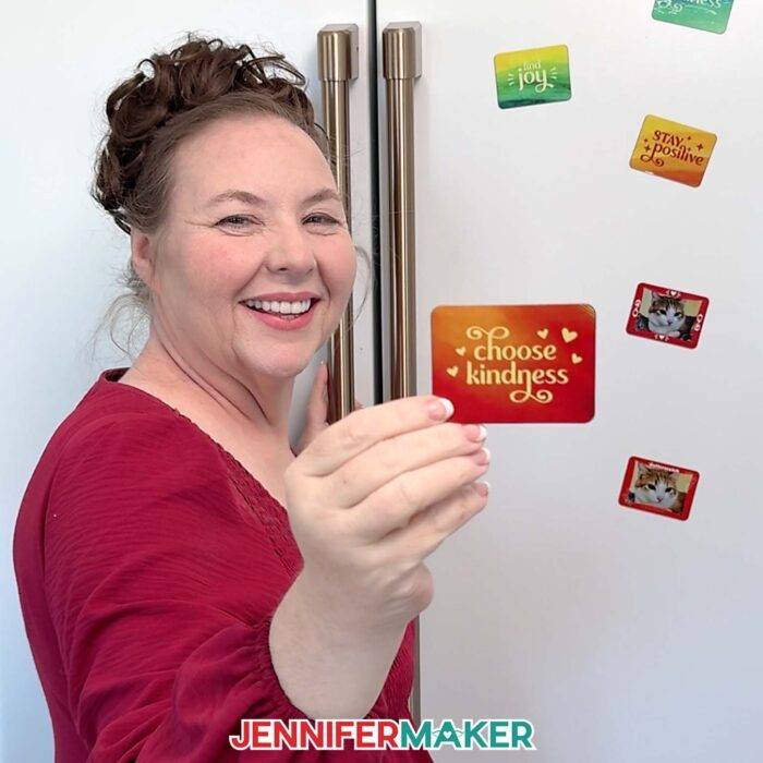 Jennifer stands in front of a fridge holding up a magnet that says "Choose kindness."
