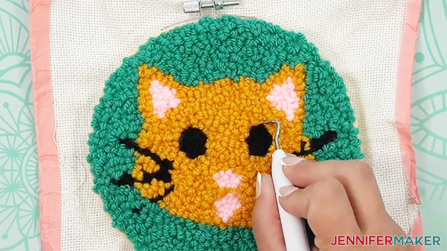 Use the weeding tool to straighten the edges of the loops where different colors of the punch needle design meet.