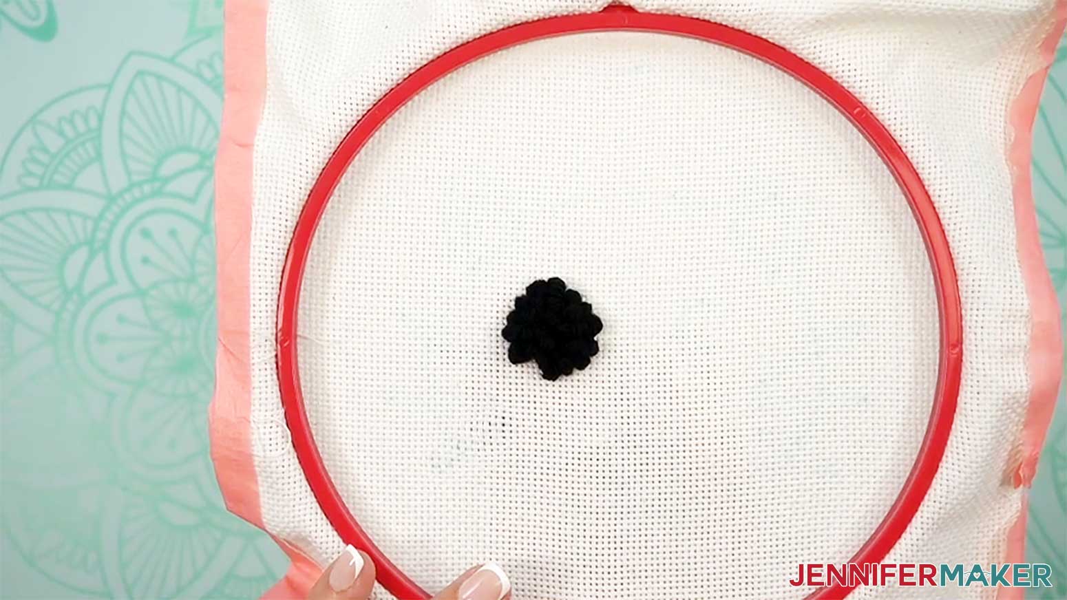Flip the hoop over to verify that the entire eye area of the punch needle design is filled in with loops.