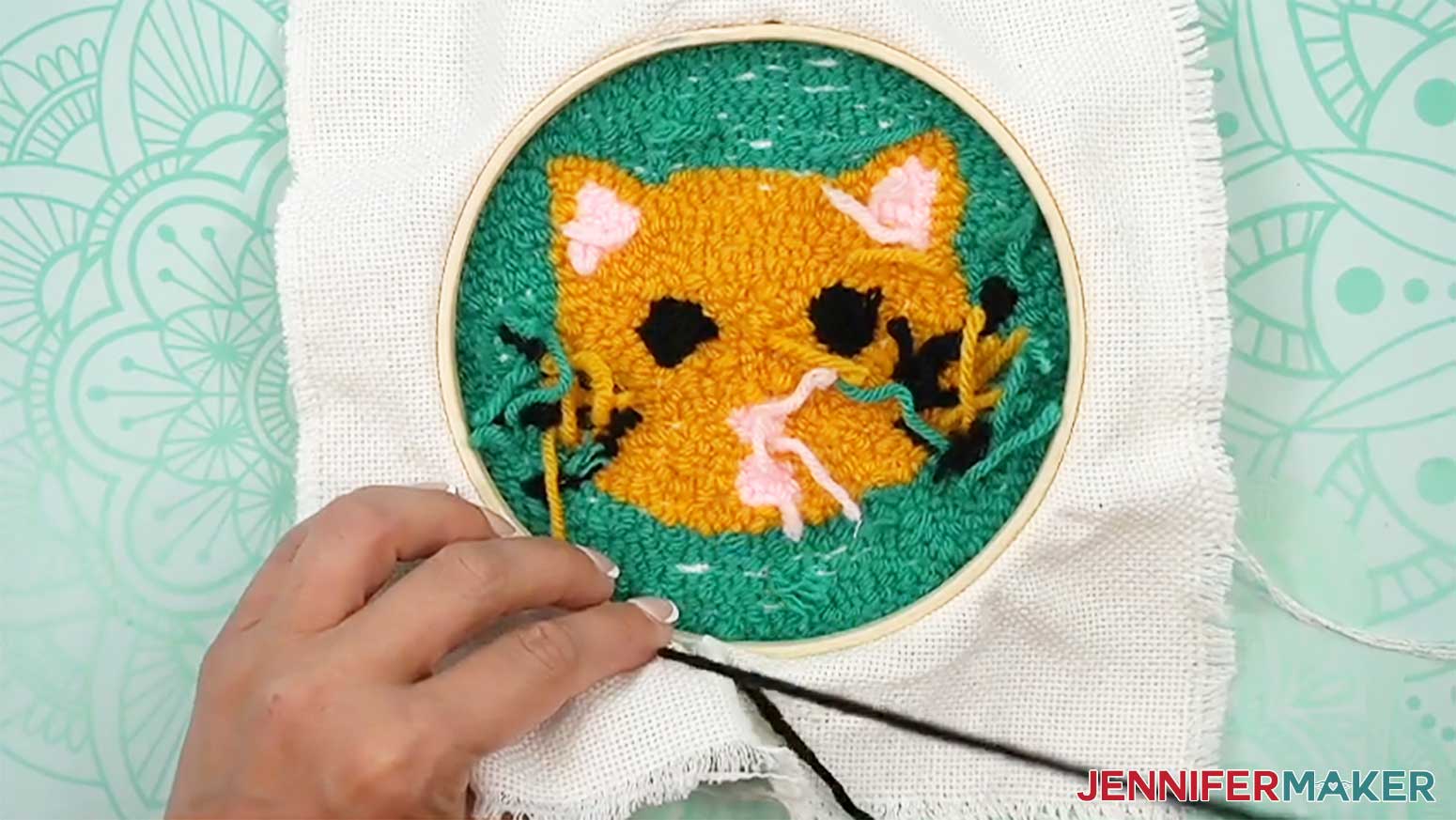 Pull the yarn through the outside edge of the material to begin finishing the back of the punch needle design.