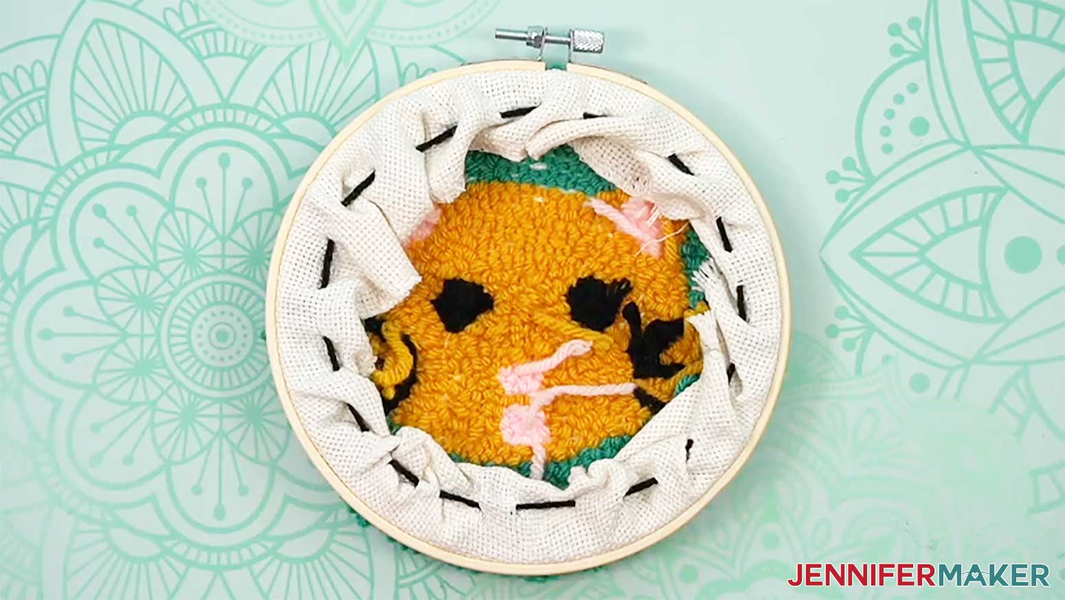 Tuck in the excess material and trim the yarn to finish the back of the punch needle design.