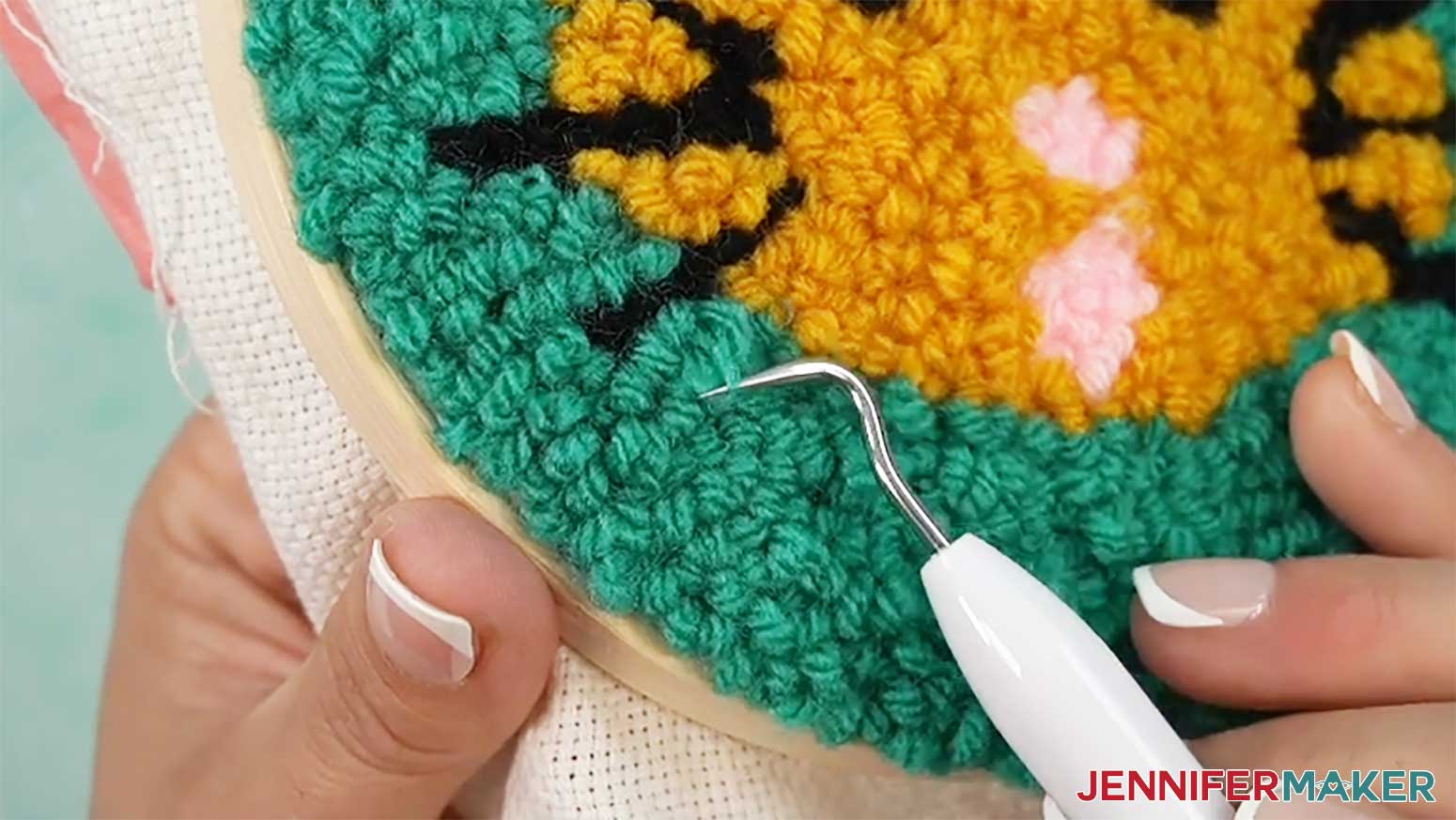 Push any loops that are too long back into the fabric to hide the extra length when finishing the punch needle design.