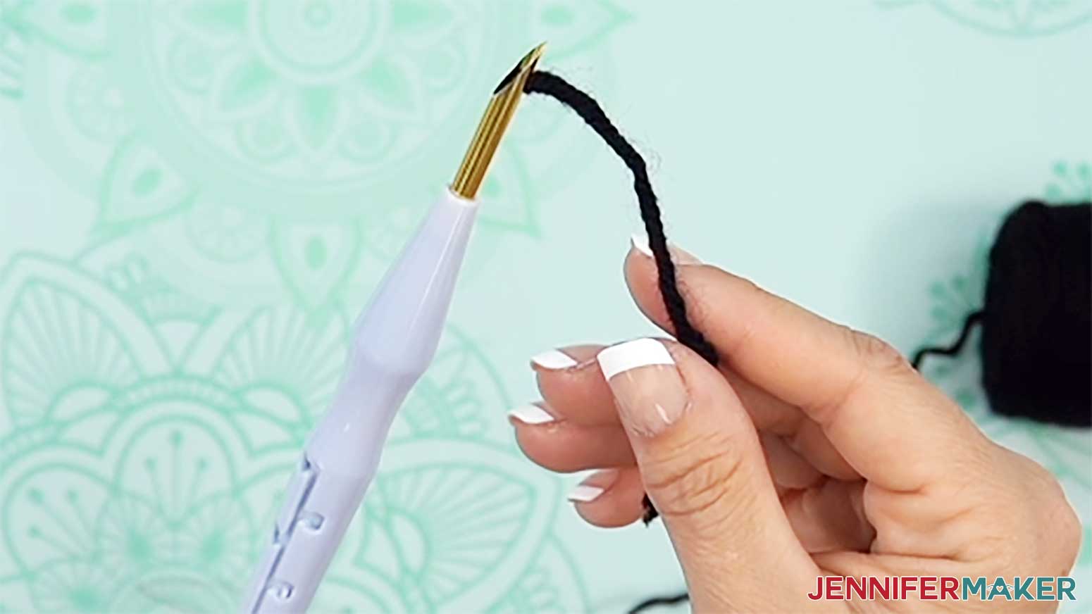 The thread is pulled through the needle and through the hole in the tip to prepare to stitch the punch needle design.