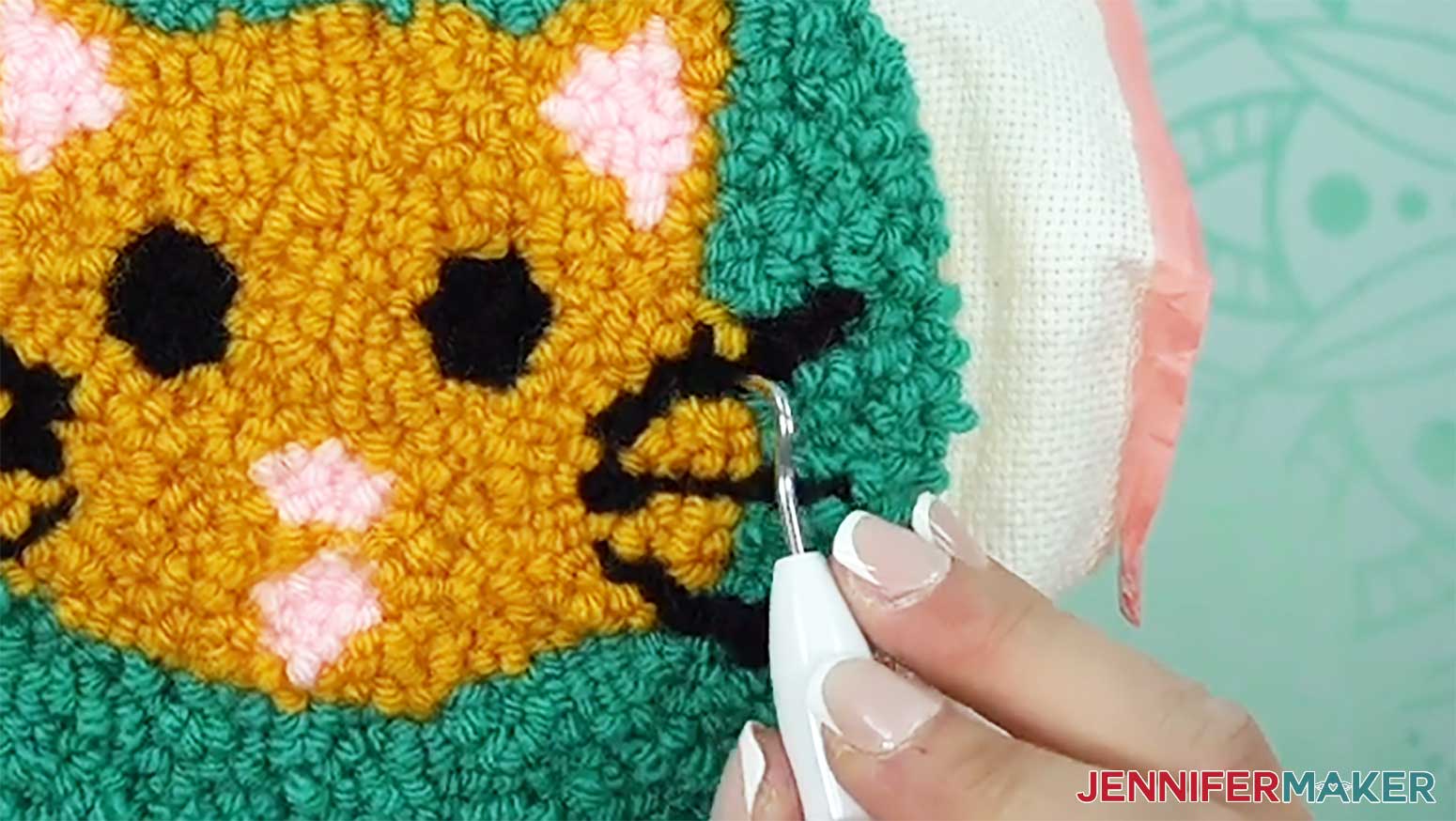 Use the weeding tool to untangle loops of different colors to finish the punch needle design.