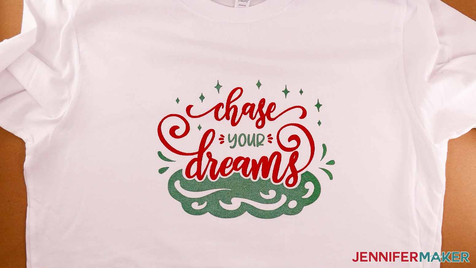 A finished white screen printed shirt with the Chase Your Dreams design in red and emerald ink