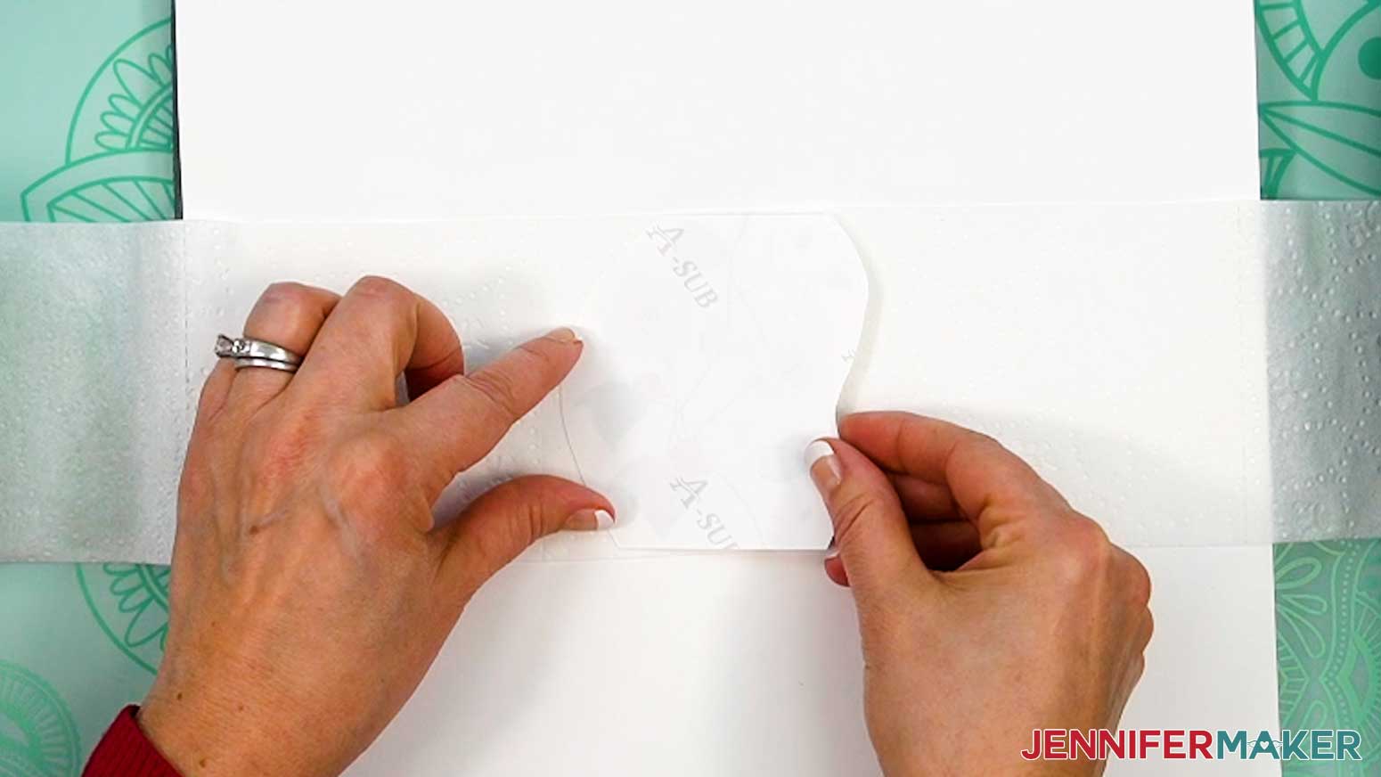 Align the bottom and top edges of the sublimation design with the bottom and top edges of the square of toilet paper.