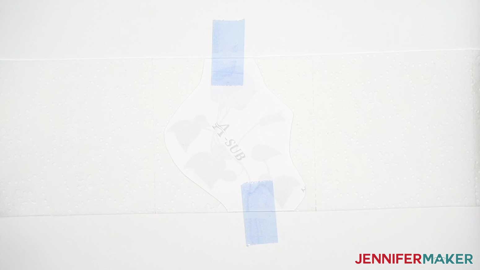 Use heat resistant tape to secure the toilet paper sublimation design to the blowout paper behind the toilet paper square.