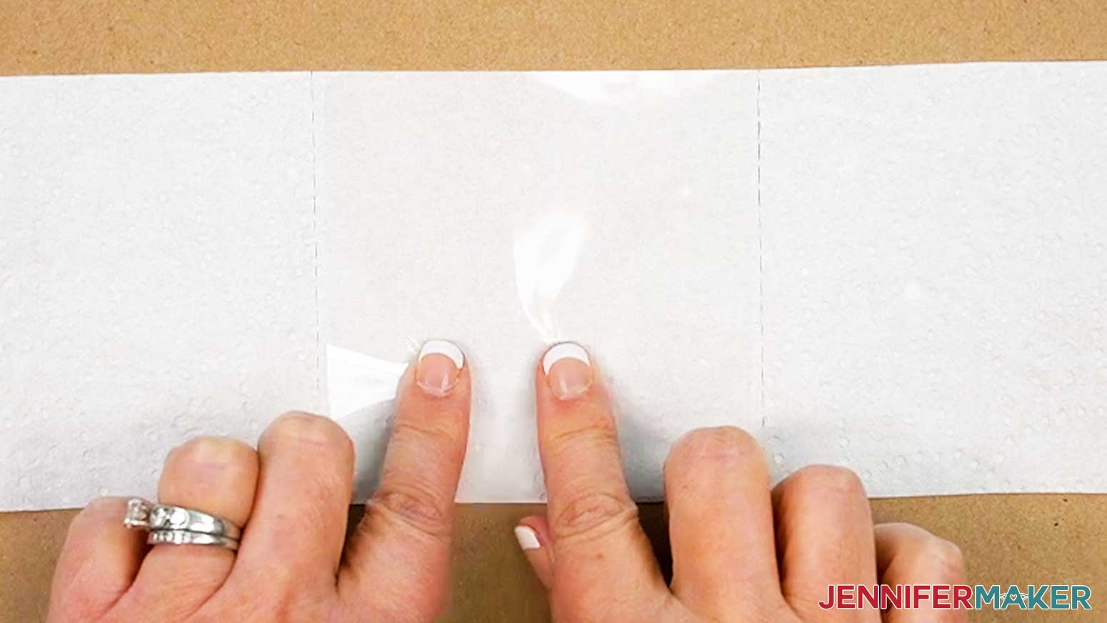 Place the square of laminate onto the toilet paper square with the shiny side facing up.