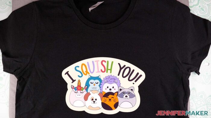 Black T-shirt with an illustrated design with cartoon animals under text "I squish you."