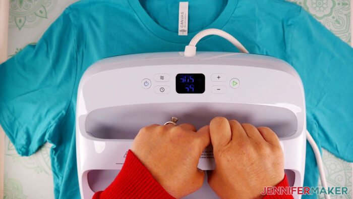 Jennifer pressing a turquoise T-shirt with her Cricut HeatPress. Learn how to use puff vinyl with JenniferMaker's new tutorial!