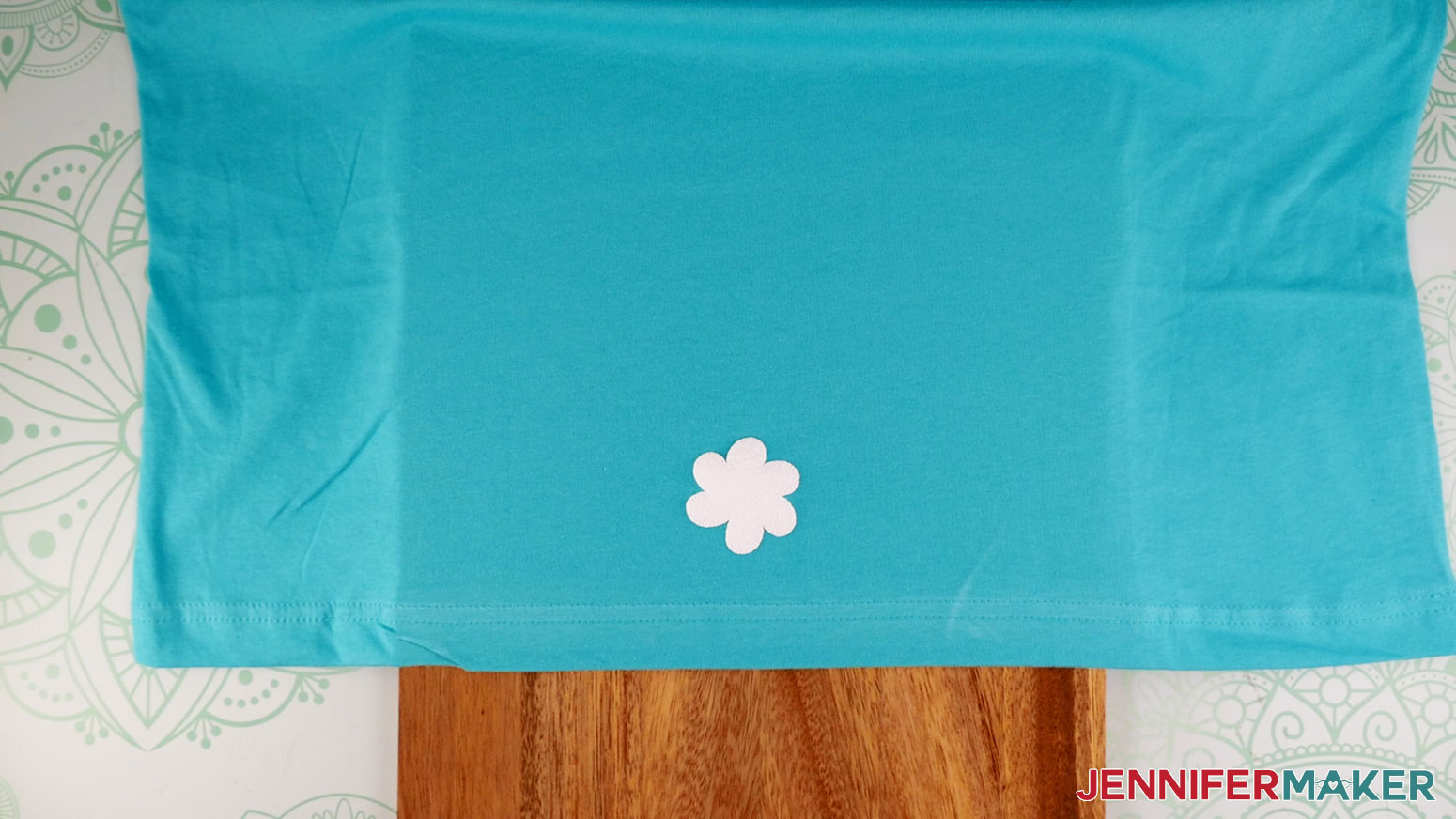 Learn how to use puff vinyl! Turquoise shirt with a flower test peeling and showing smooth puff vinyl texture.