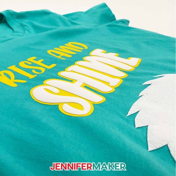 How to use Puff Vinyl! Turquoise blue shirt with the words "Rise and Shine" outlined in yellow HTV, with a porcupine made from white puff vinyl. Learn how to make 3D puff vinyl T-shirts with JenniferMaker's tutorial!