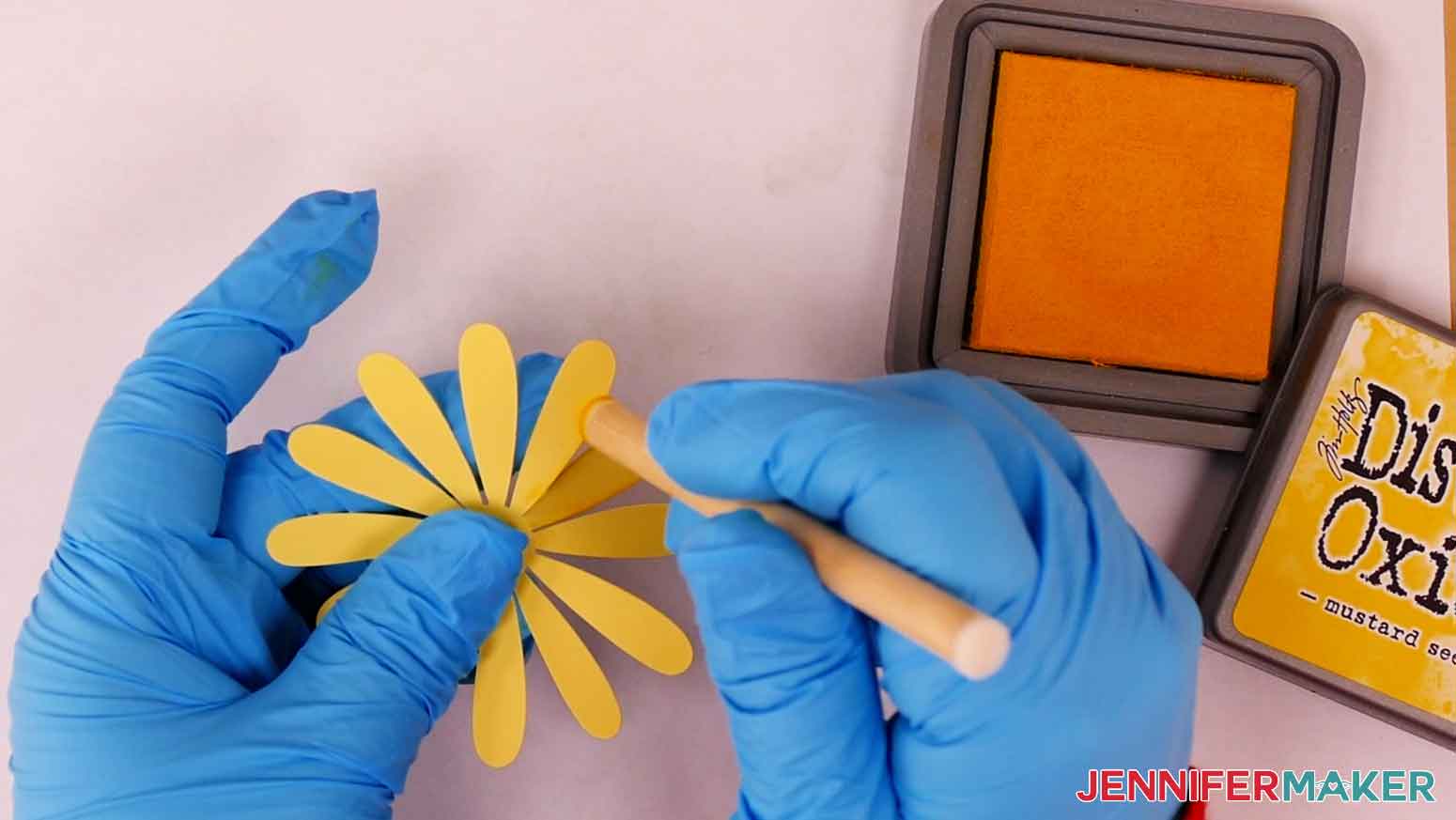 Apply yellow distress oxide to the edges of the daisy petals with a detail blending tool.