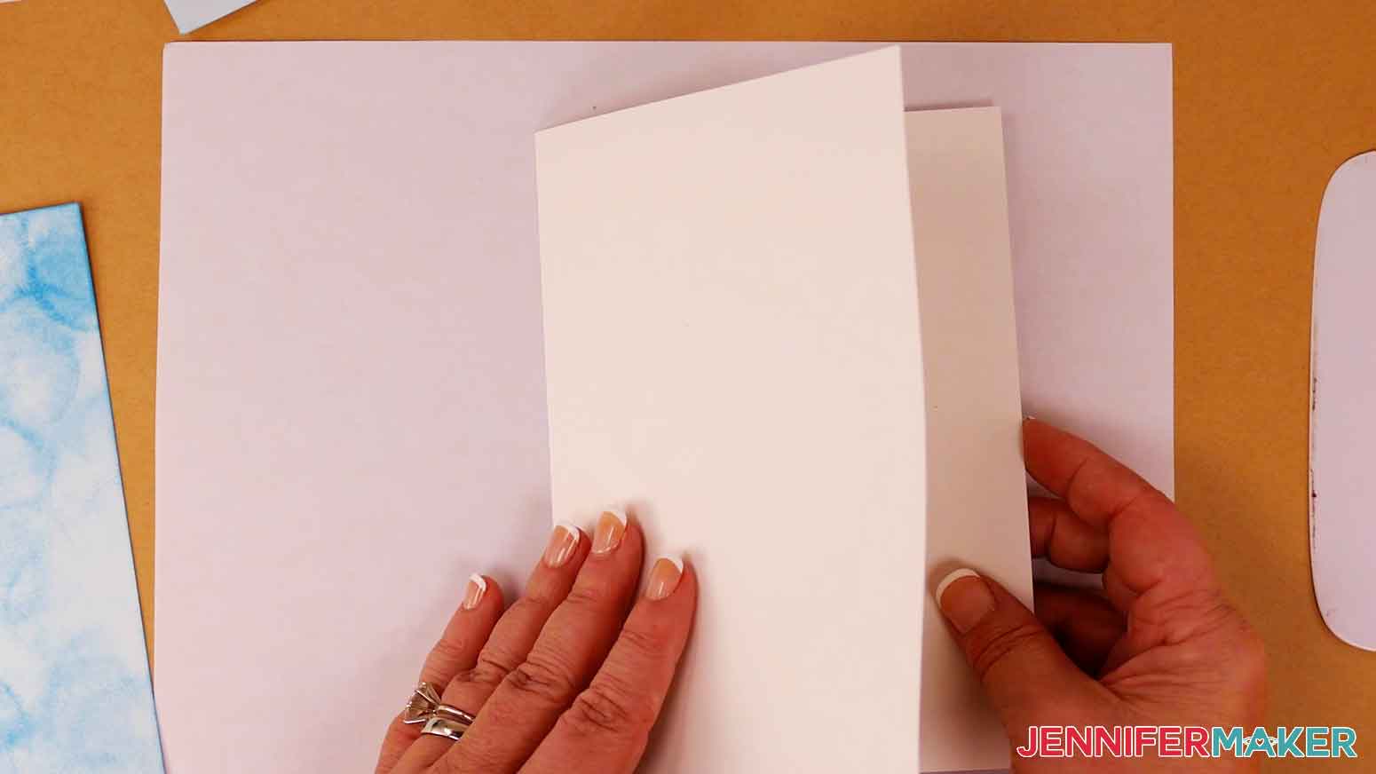 Fold the blank card piece in half along the dashed cut line.