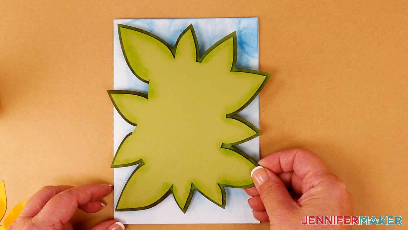 Place the leaf layers on the sky layer with a slight overhang of leaves around the card.