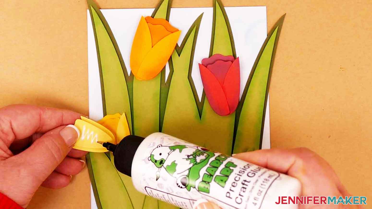Apply craft glue to the back of each tulip flower and attach to the leaves on the card.