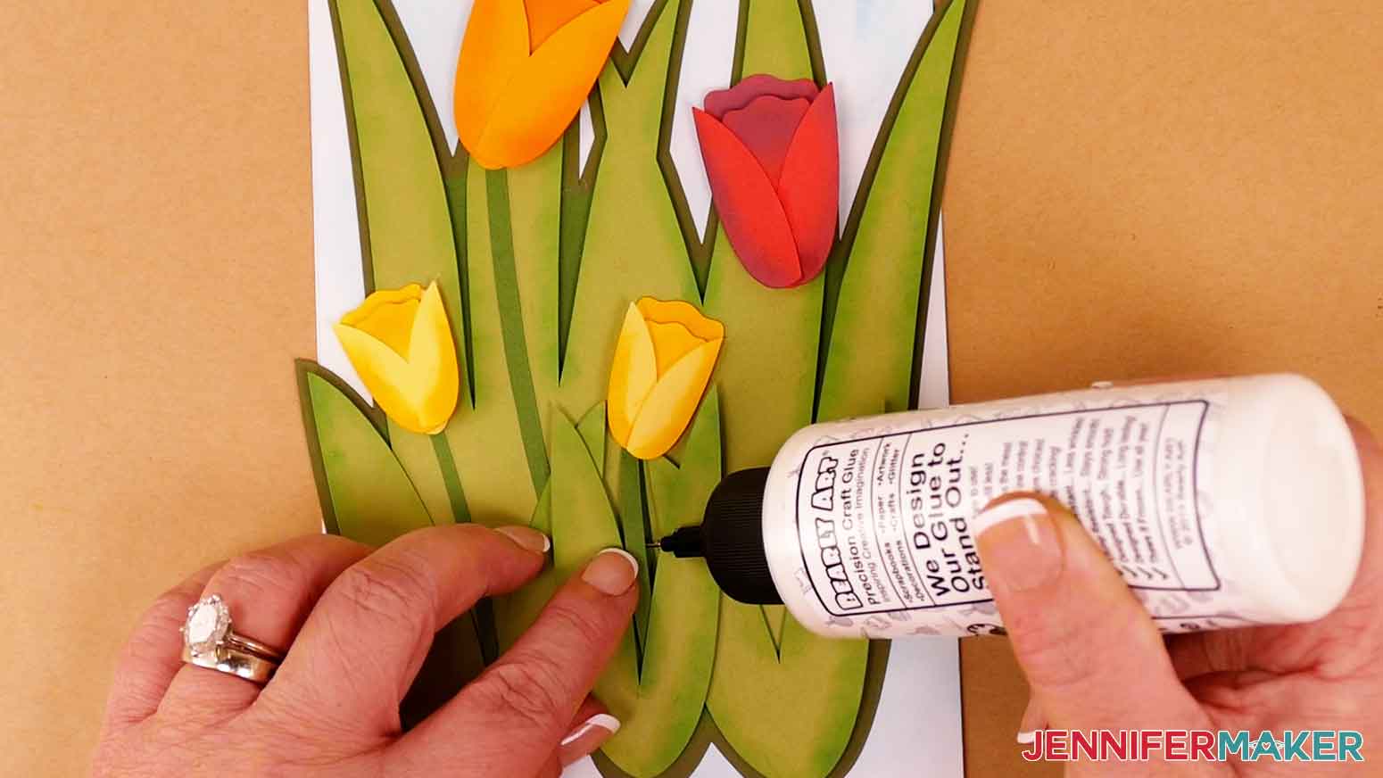 Insert the stems under the flowers and leaves and use small dots of craft glue to secure them in place.