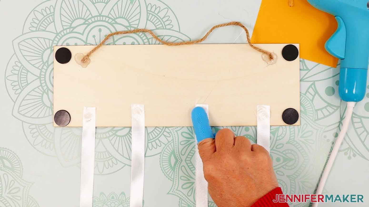 Apply the remaining three ribbons to the bottom of the wood panel.