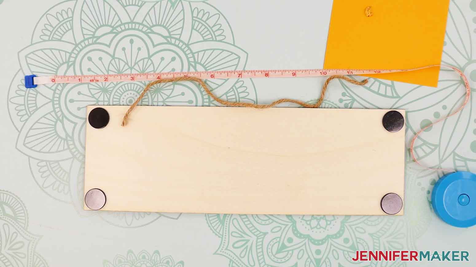 Measure and cut twine and place the left end on the wood base panel.