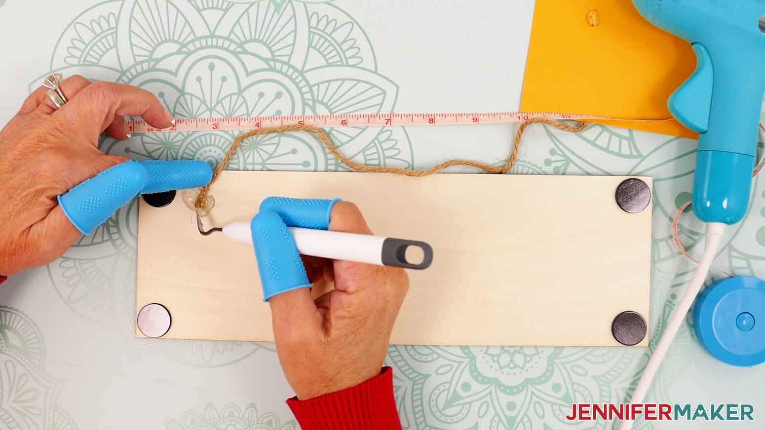 Apply hot glue and use a weeding tool to press the twine into the glue.