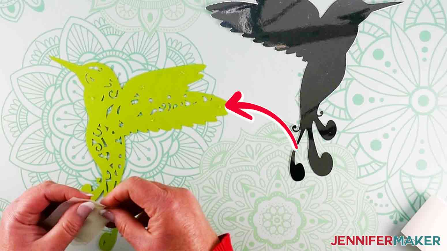 Red arrow pointing to suggested placement of clear adhesive Zots on the hummingbird's wing with intricate cuts on Cricut.