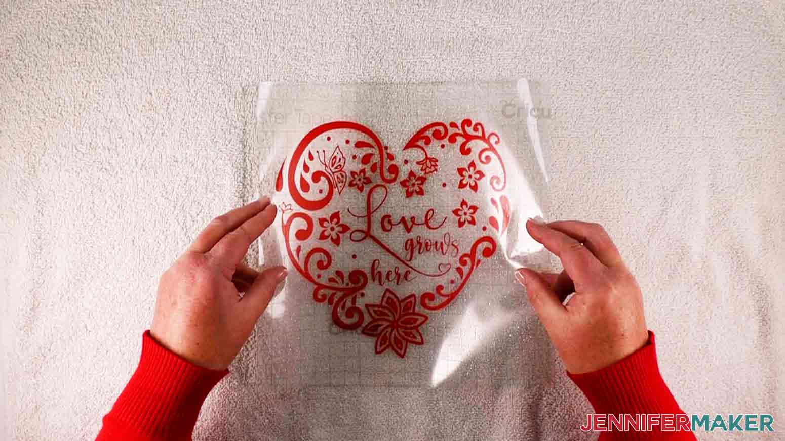 Aligning intricate hearts decal on glass with tape
