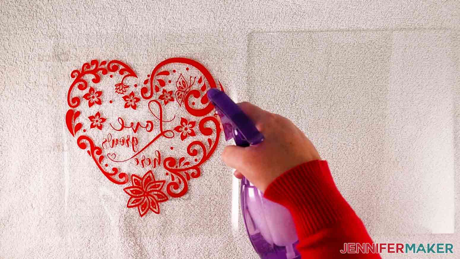 Spray intricate hearts decal and glass with a fine mist