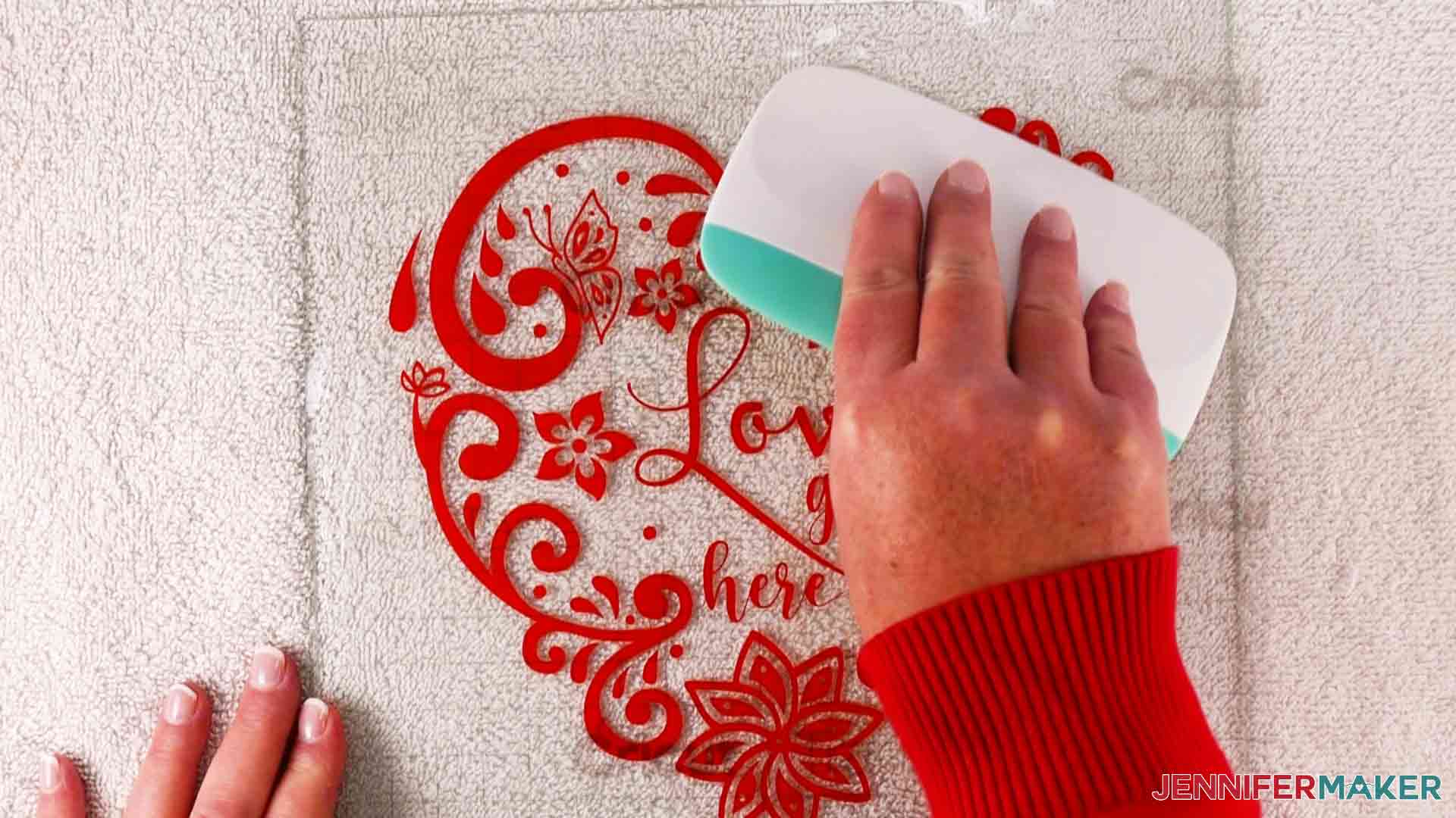 Squeegeeing intricate hearts decal onto glass