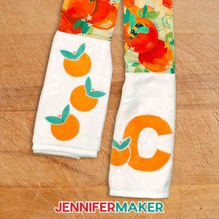 Kitchen boa scarf with oranges and bees fabric for the neck, Infusible Ink oranges on one towel end, and a capital C on the other.