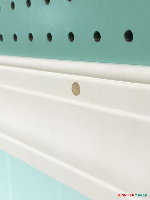 Spackling over the screw heads on our large framed pegboard