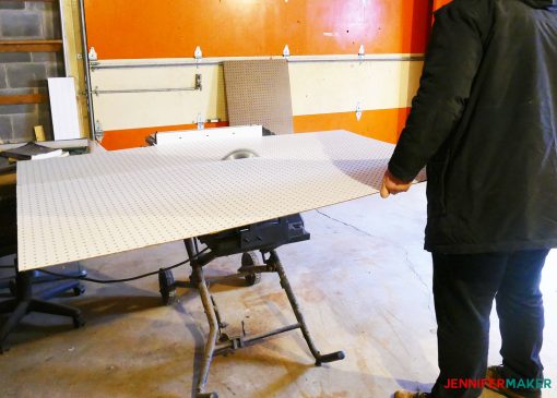 Cutting our large sheet of pegboard on a table saw