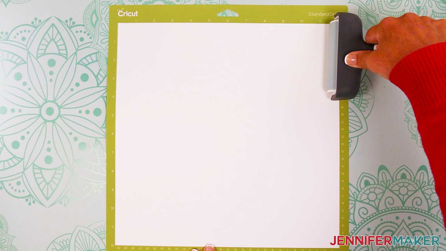 Use a brayer to fully adhere the white cardstock to the green machine mat.