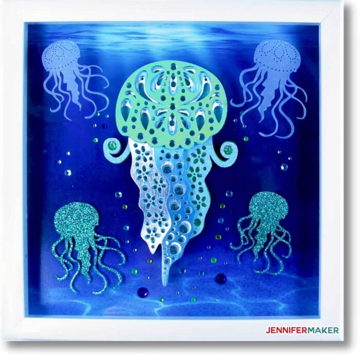 Layered Jellyfish Mandala in green and blue cardstock with rhinestone droplets, framed in a white shadow box