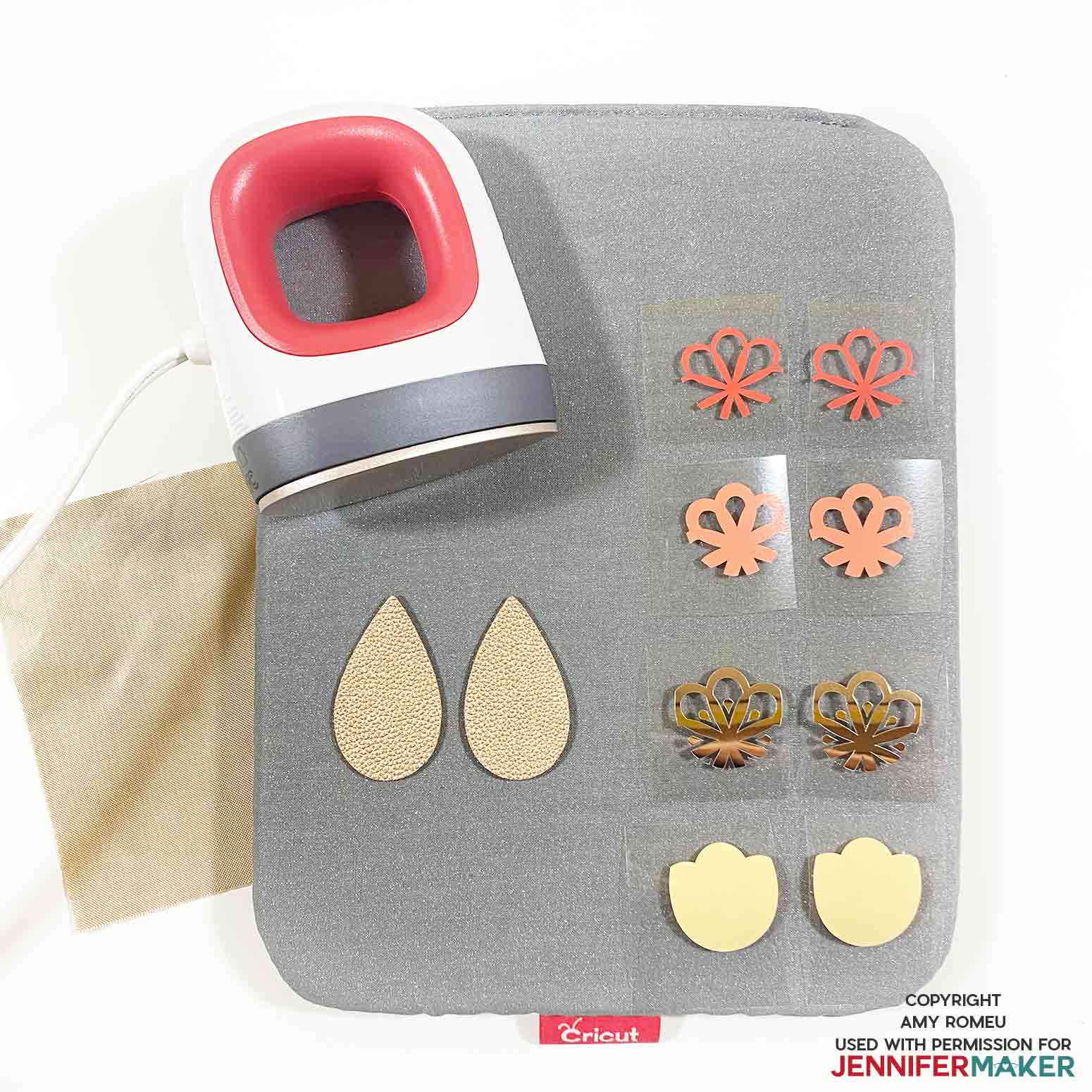 Cricut easy press mini and vinyl earring shapes on a pressing pad