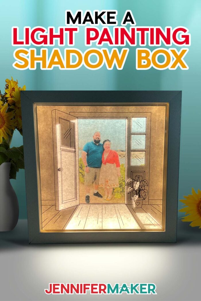 Make a light painting shadow box with JenniferMaker's tutorial! An illuminated shadowbox frame sits upon a table surrounded by sunflowers and a pretty blue backdrop. The shadowbox features a drawn doorway image with a real photo of Jennifer and Greg inside. The lights inside the box cast light rays across the floor of the image.