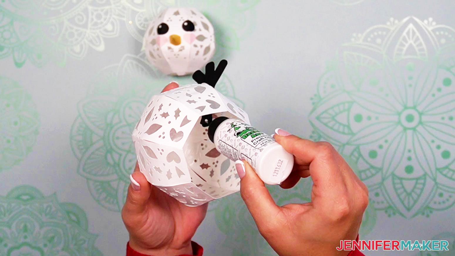 Add glue to the arm tabs inside the body of the light up snowman