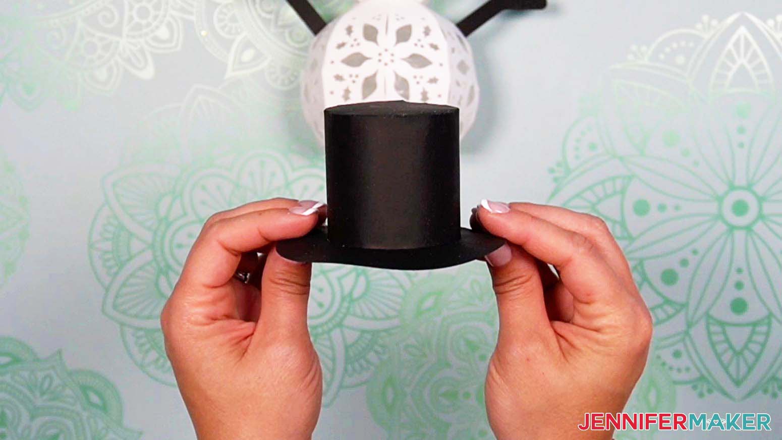 Attach the brim of the light up snowman's hat to the assembled top hat piece using the tabs