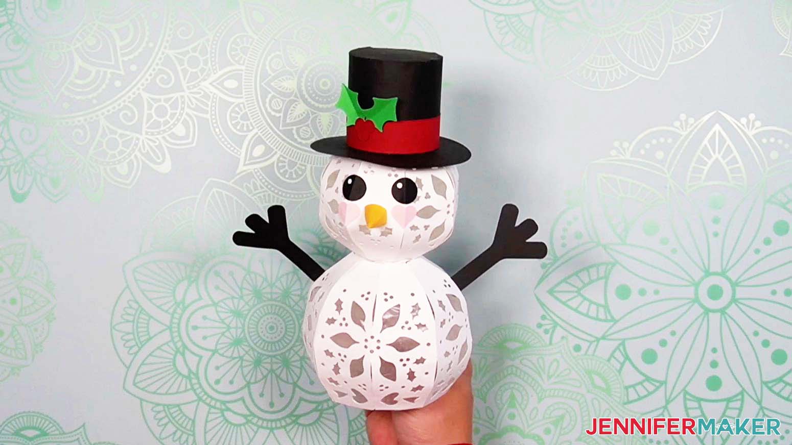 Attach the folded holly leaves and berry piece to the light up snowman's hat on top of the ribbon piece