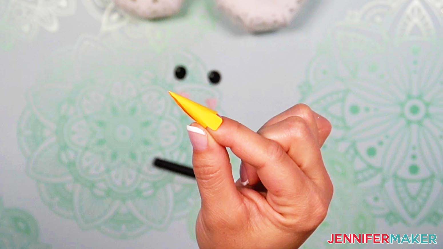 Roll the light up snowman's nose piece into a cone shape with your fingers, so the two tabs are opposite each other