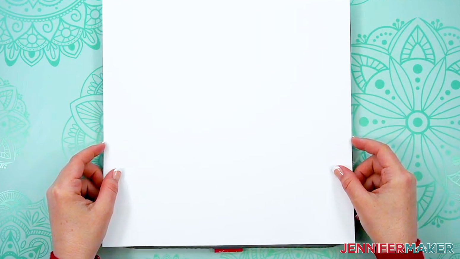 A pair of hands hold a brand new blank piece of 12" x 12" cardstock.