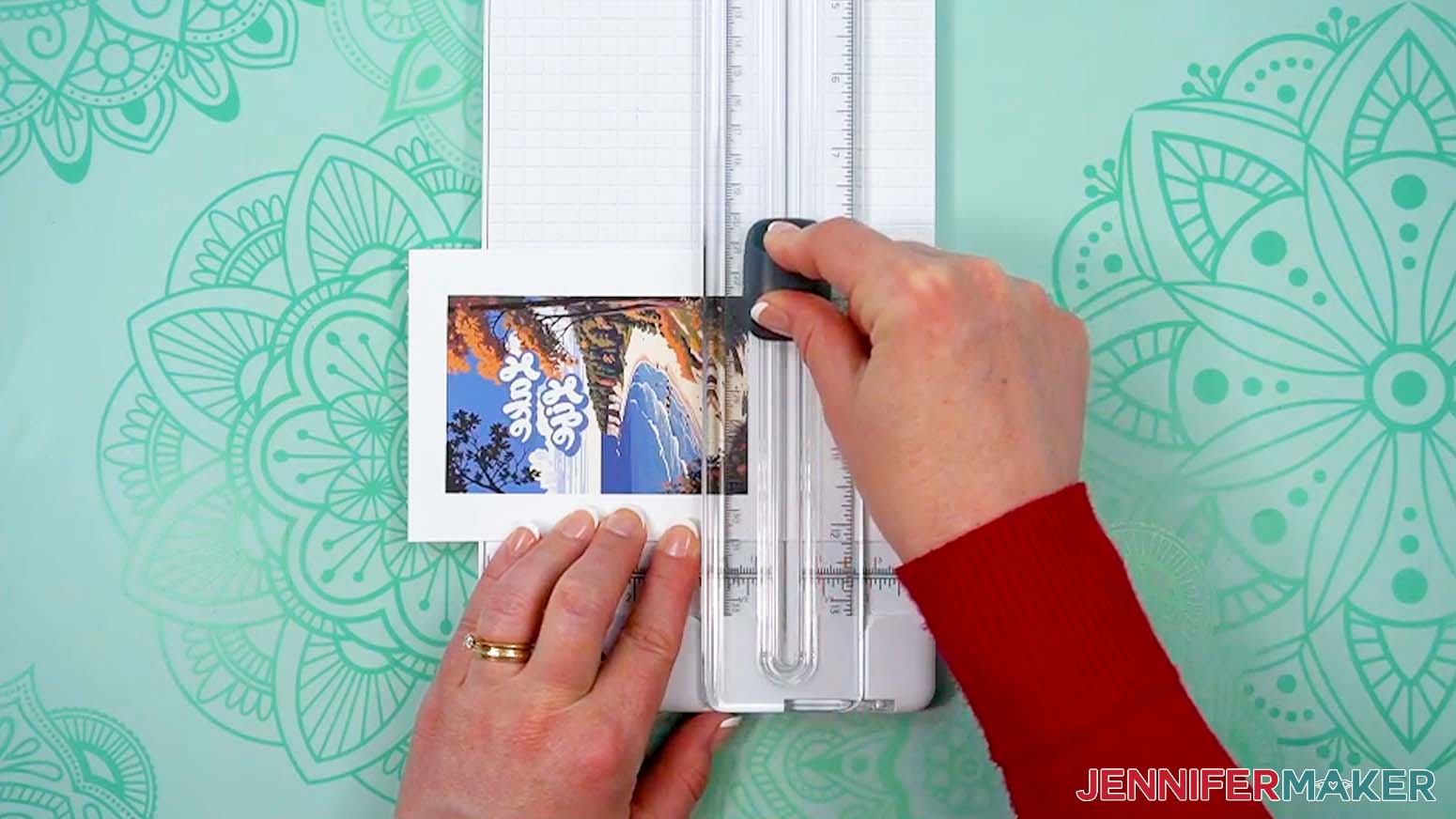 A trimmer is being used to cut down the printed paper to a good size for pressing.